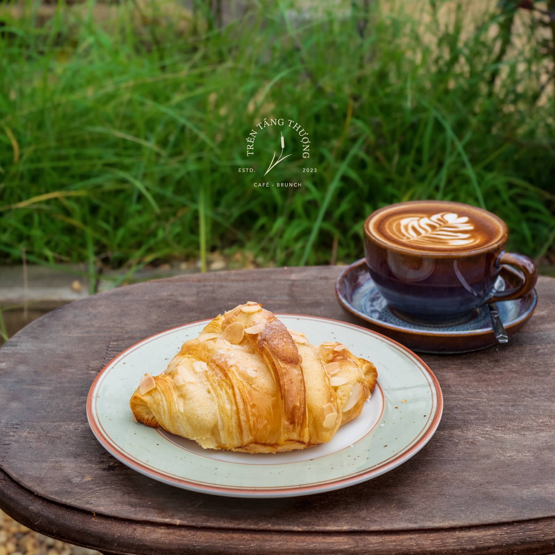 Bánh croissant và cà phê trong không gian xanh